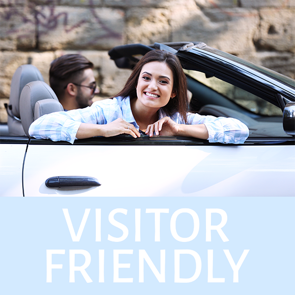 Young couple in convertible labeled Visitor Friendly