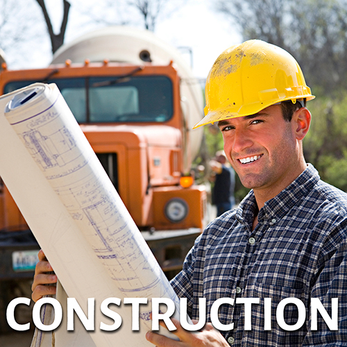 Construction contractor holding roll of building plans - link