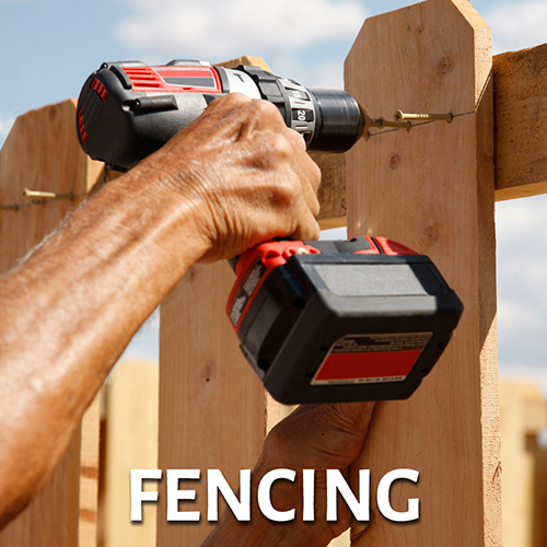 Closeup of builder's hand holding drill to build a fence - link